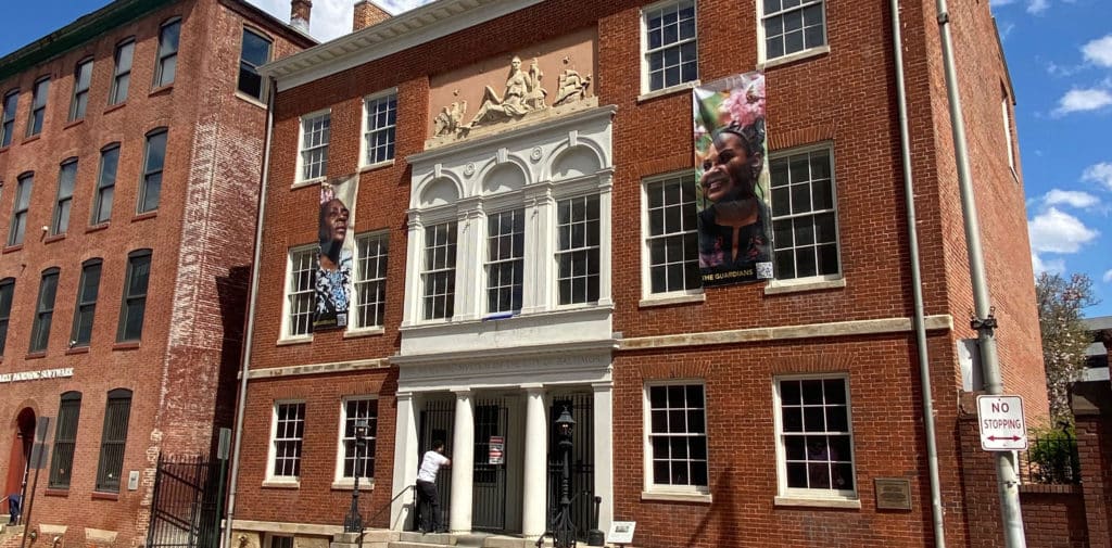 The brick facade of the Federal-style Peale building, with three bays and white columns in the front.