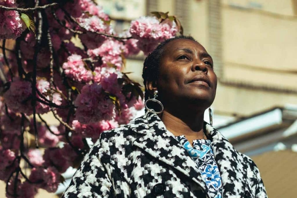 Audrey Carter has braids in her hair and wears a herring bone pattern, black and white blazer.