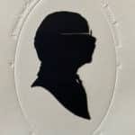 A historic silhouette of a man's face on thick white paper.