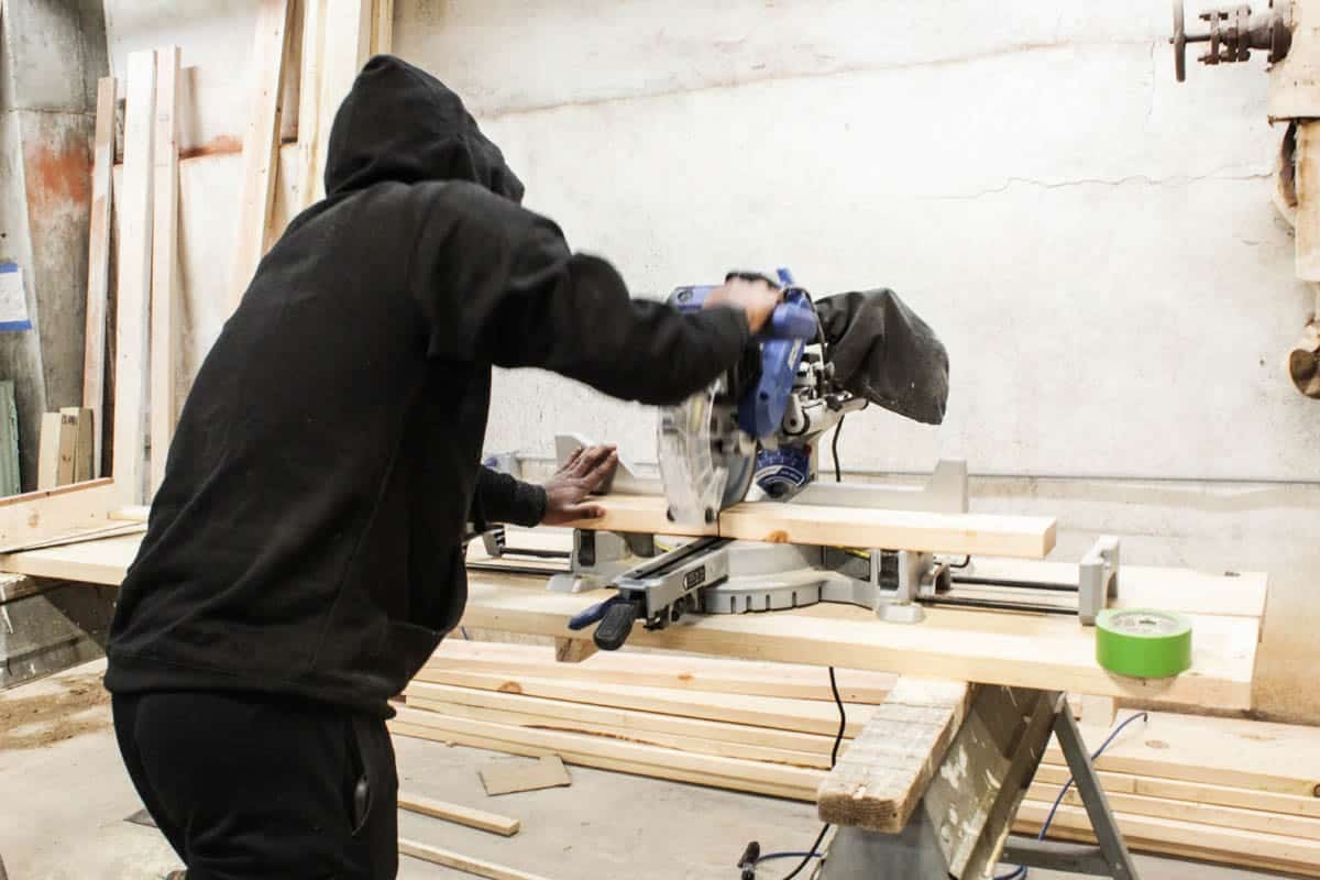 A person uses a circular saw in a workshop.