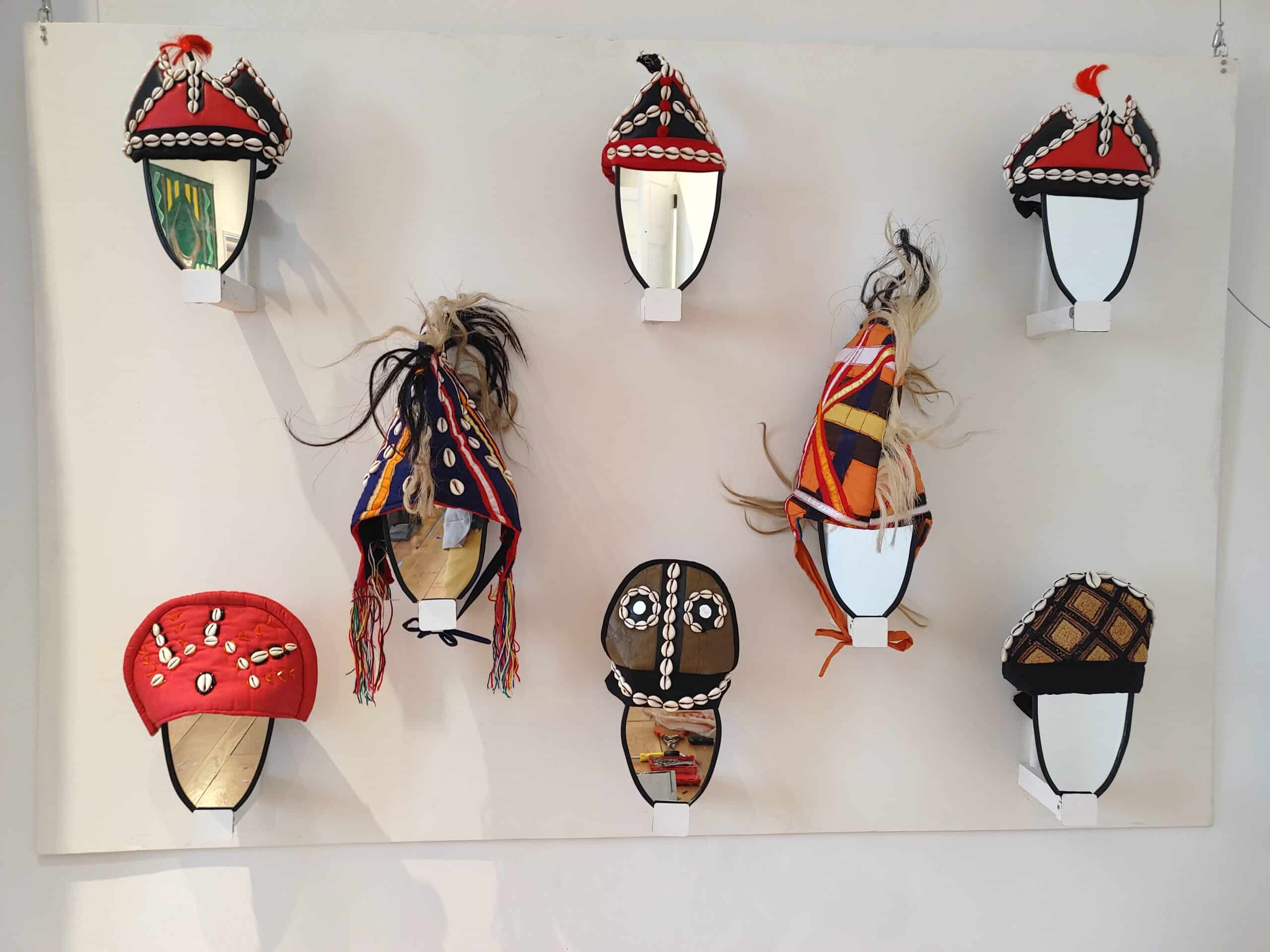 Colorful African masks displayed on a gallery wall in a museum.