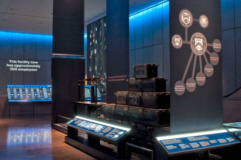 A museum exhibition space that features cases of old trunks and educational graphics and text.