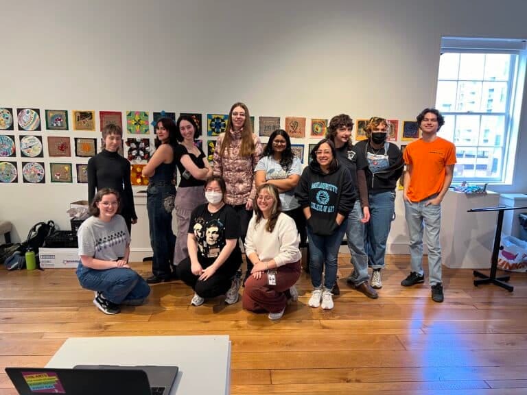 A group of students pose in front of their artwork at The Peale.