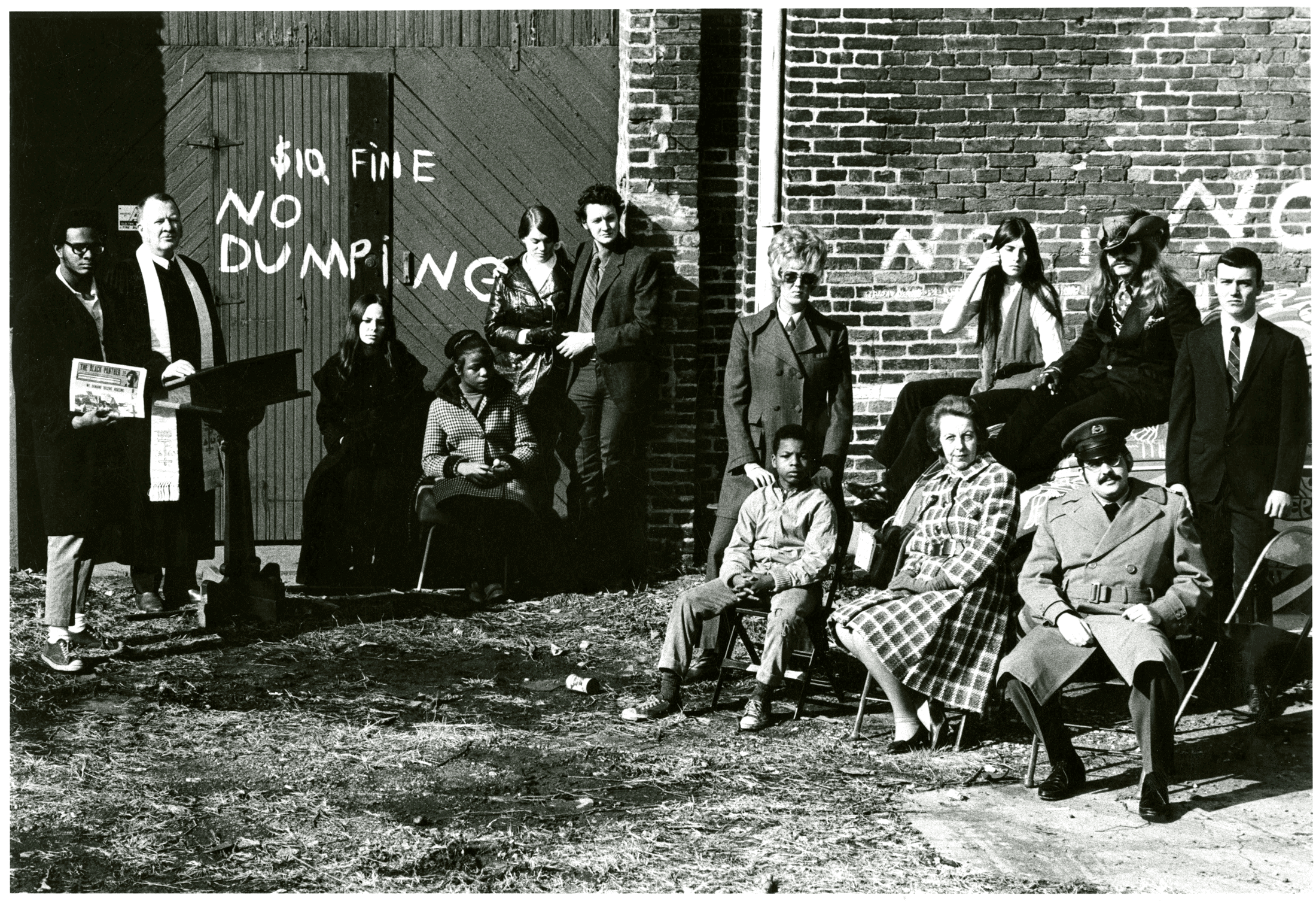 Vintage 1960s photo of Black and White people standing in front of a brick wall.