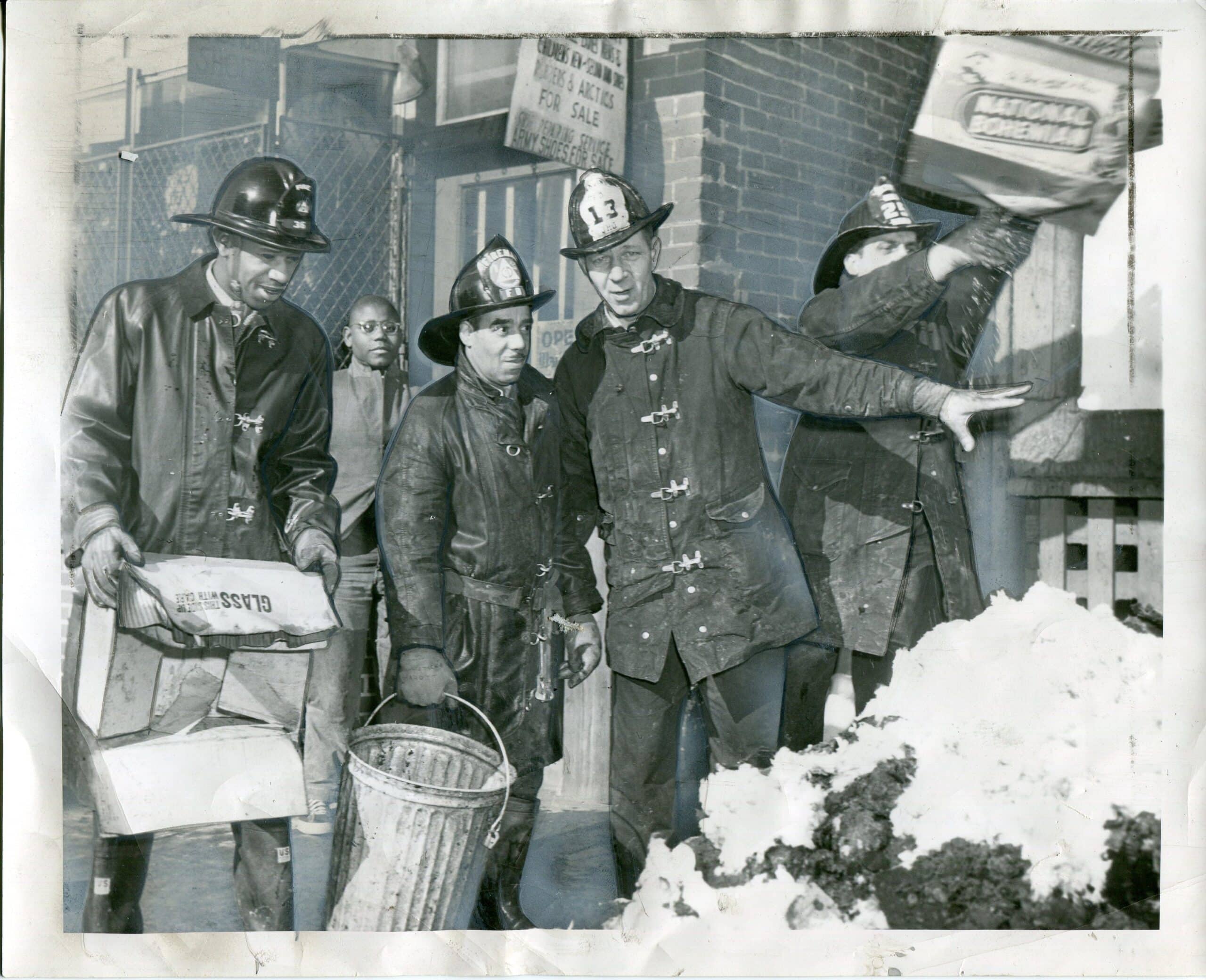 Vintage view of integrated fire department and fire fighters in full gear on a street.