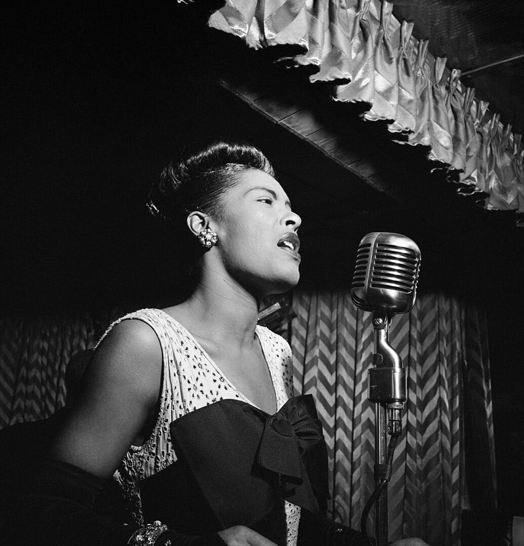Billie Holiday sings in a 1947 image of her in front of a microphone.